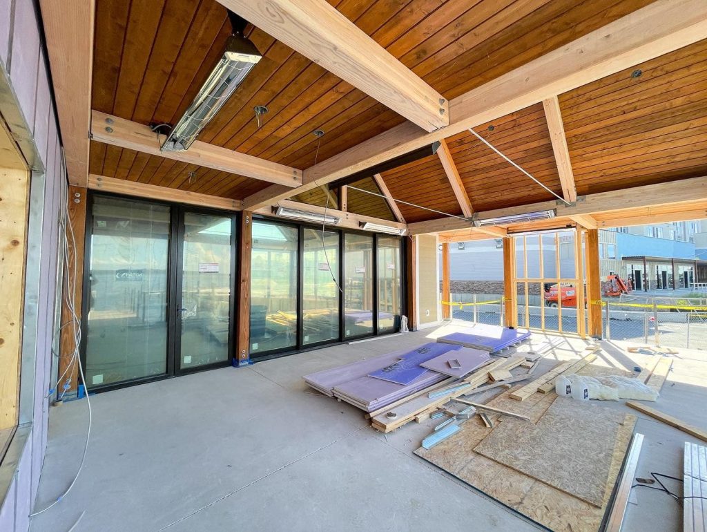 Construction in progress of large dining room with wood ceiling and water views